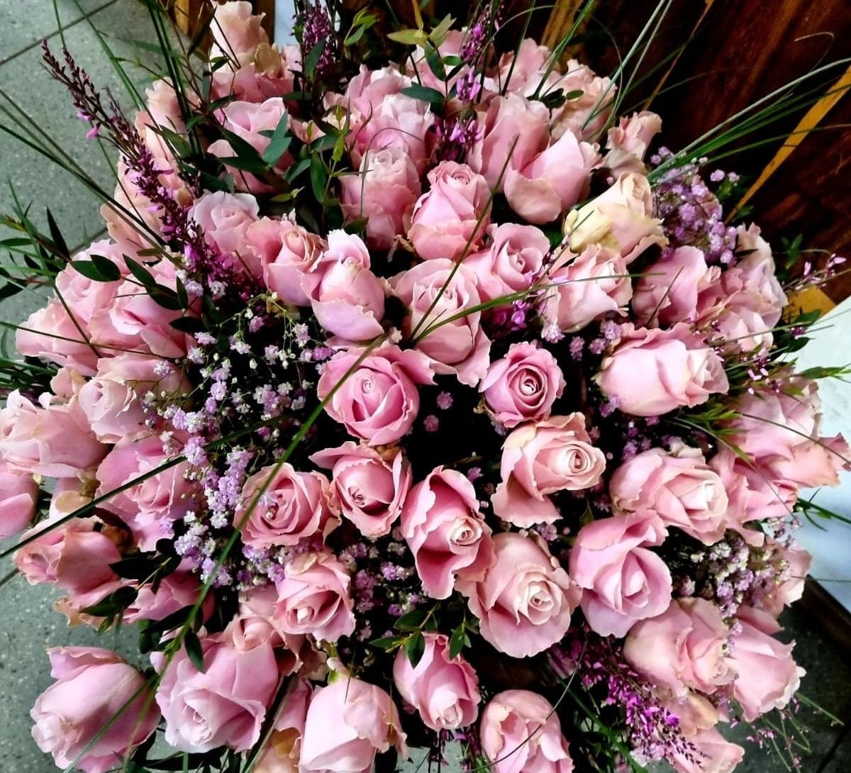 Großer handgebundener Strauß aus rosa Rosen mit Schleierkraut und Gräsern